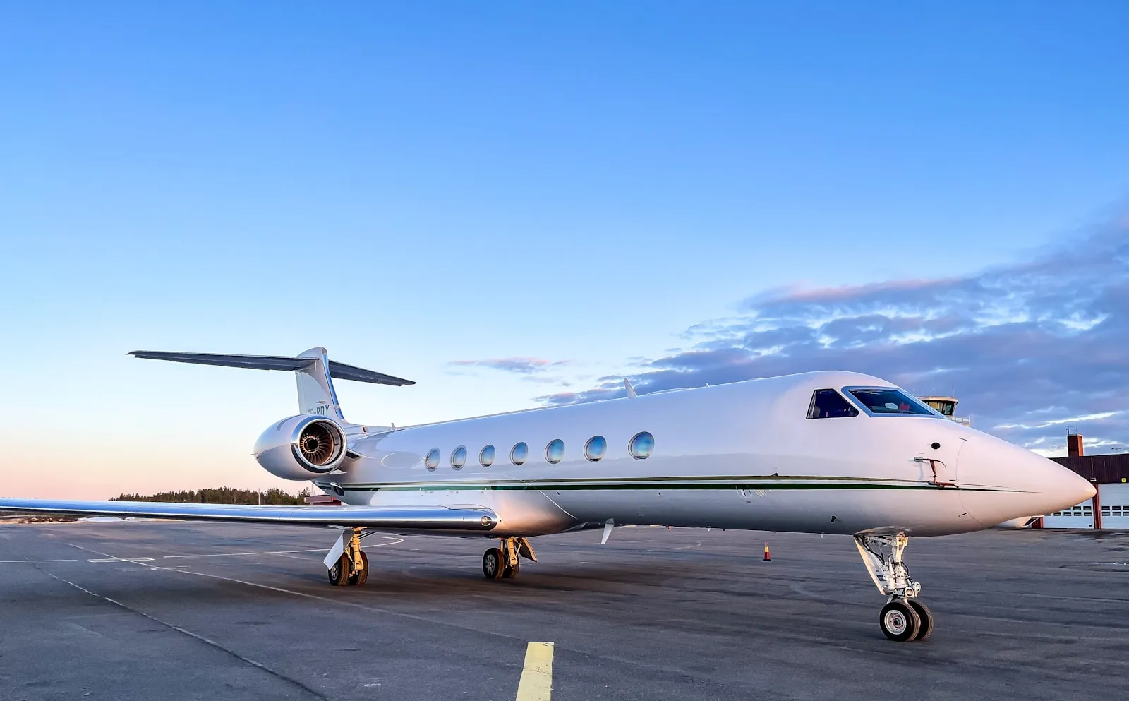 White private business jet parked on an airport apron