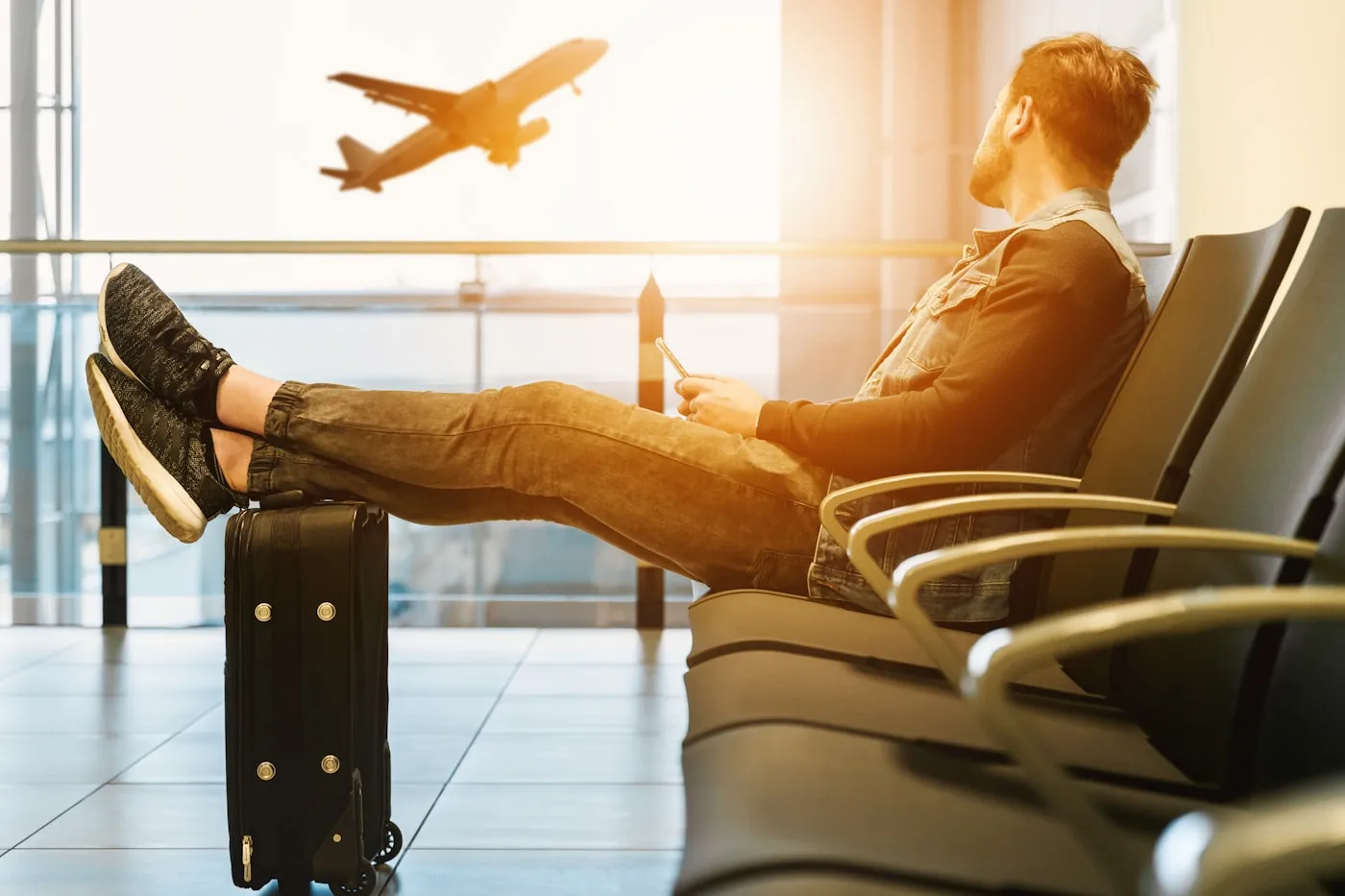Traveller waiting at an airport while an aircraft departs